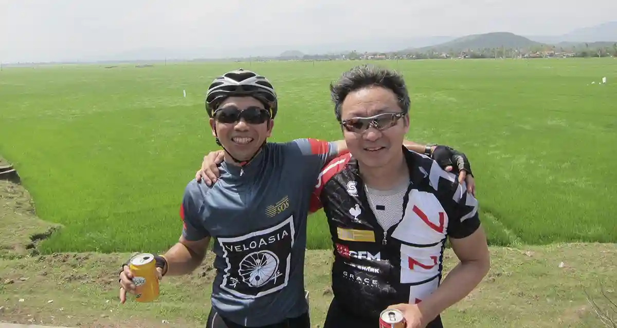 Cyclists resting by rice fields