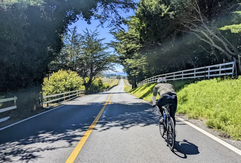 Cyclist riding empty Highway 1 along the Mendocino coastline in Northern California.